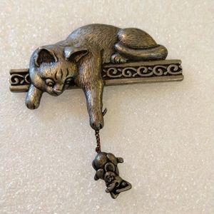 J.J. cat with dangling mouse brooch.